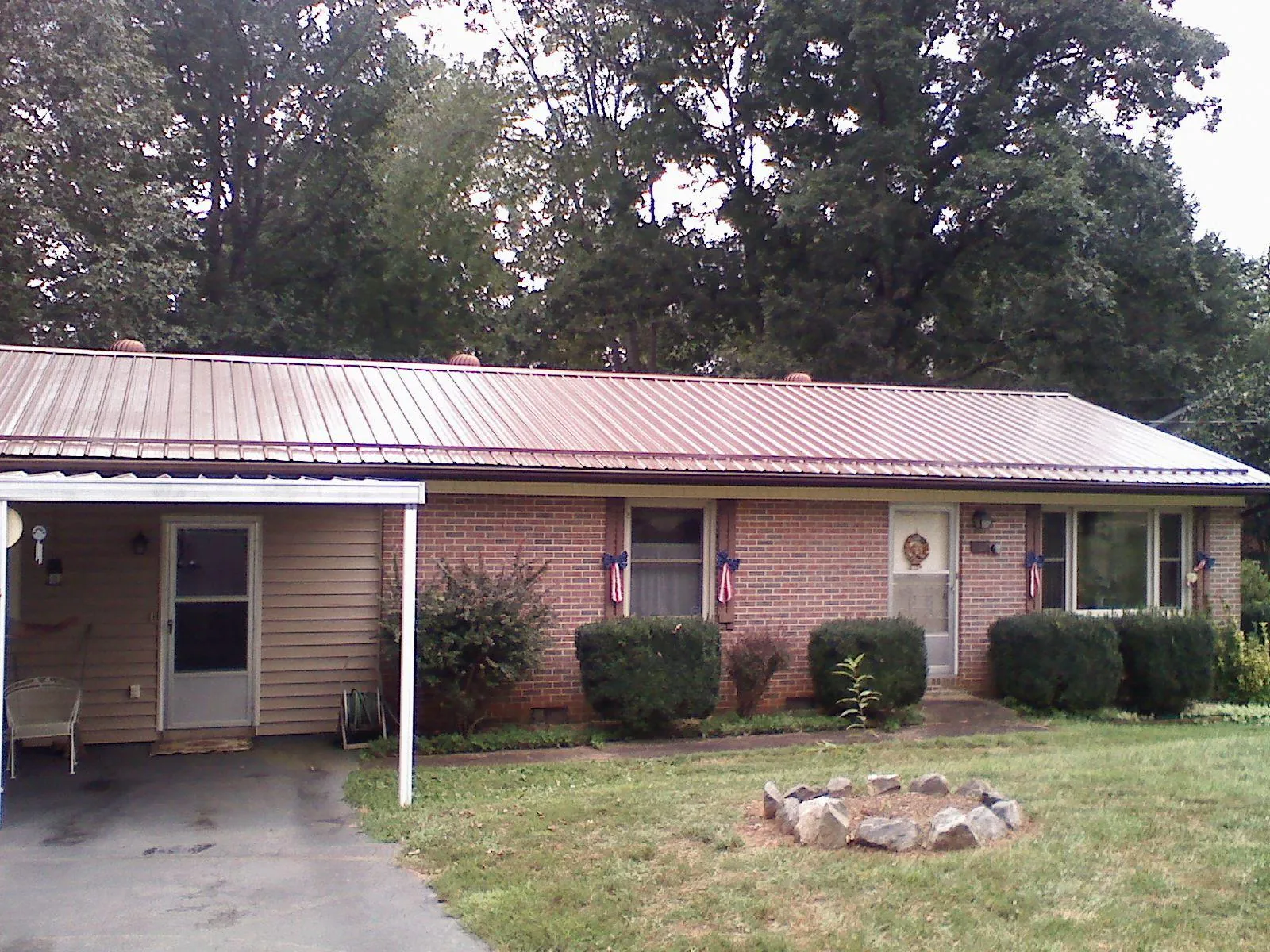 Bronze metal roof and carport on a brick ranch home — Roof Repair work by our crew in Calmar