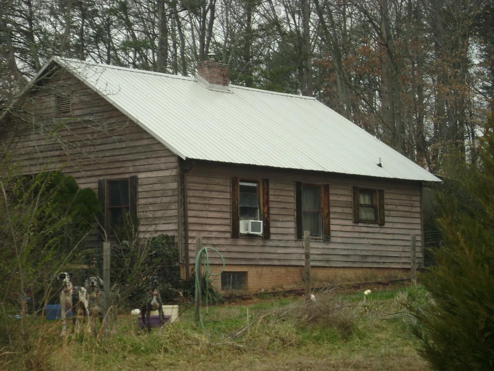 White metal roof on an old wood sided farmhouse, from a Metal Roof Installation job in Calmar
