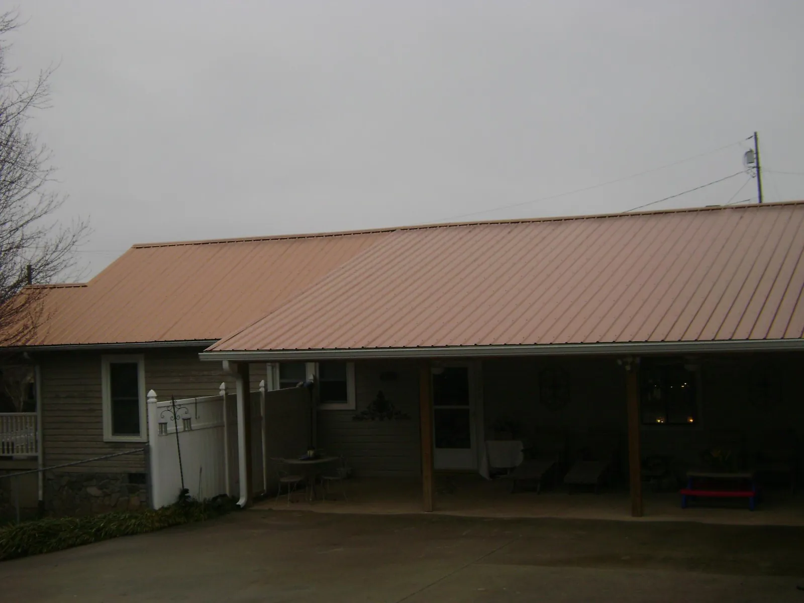 Copper toned metal roof over a wide covered patio in Calmar